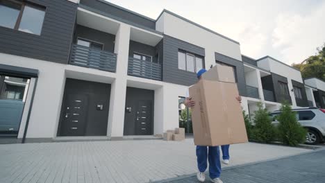 two young workers of removal company are loading boxes and furniture into a minibus