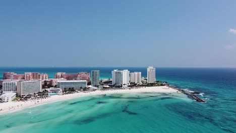 luxury hotel at cancun bay along white beach, mexico. aerial forward ascending and blue sky for copy space
