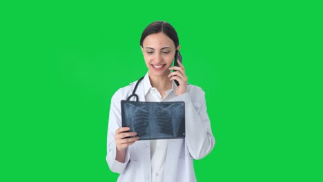 happy indian female doctor explaining x ray report on call green screen