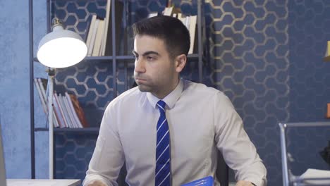 el hombre de negocios que mira los documentos de la carpeta está cansado e infeliz.