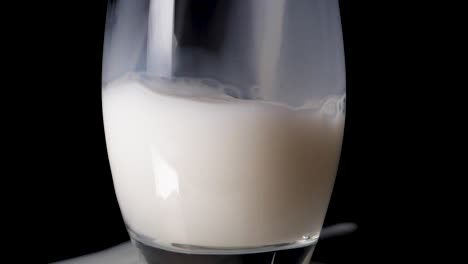 close up shot of pouring vegan rice milk in a glas in slow motion