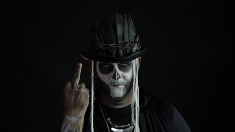 Finsterer-Mann-Mit-Totenkopf-Make-up,-Der-Grimassen-Schneidet-Und-Den-Mittelfinger-Zeigt.-Geste-Mit-Schlechtem-Benehmen.-Halloween