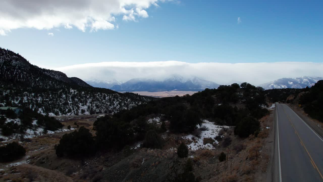 volando sobre una carretera remota con montañas en la distancia