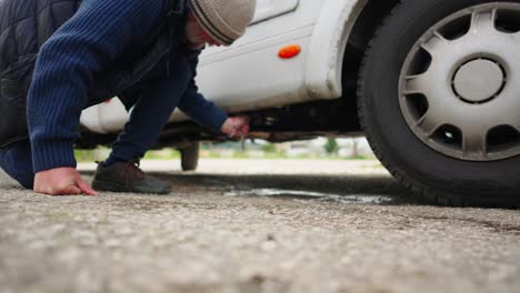 a man uses a handle to drain grey waste water from a caravan