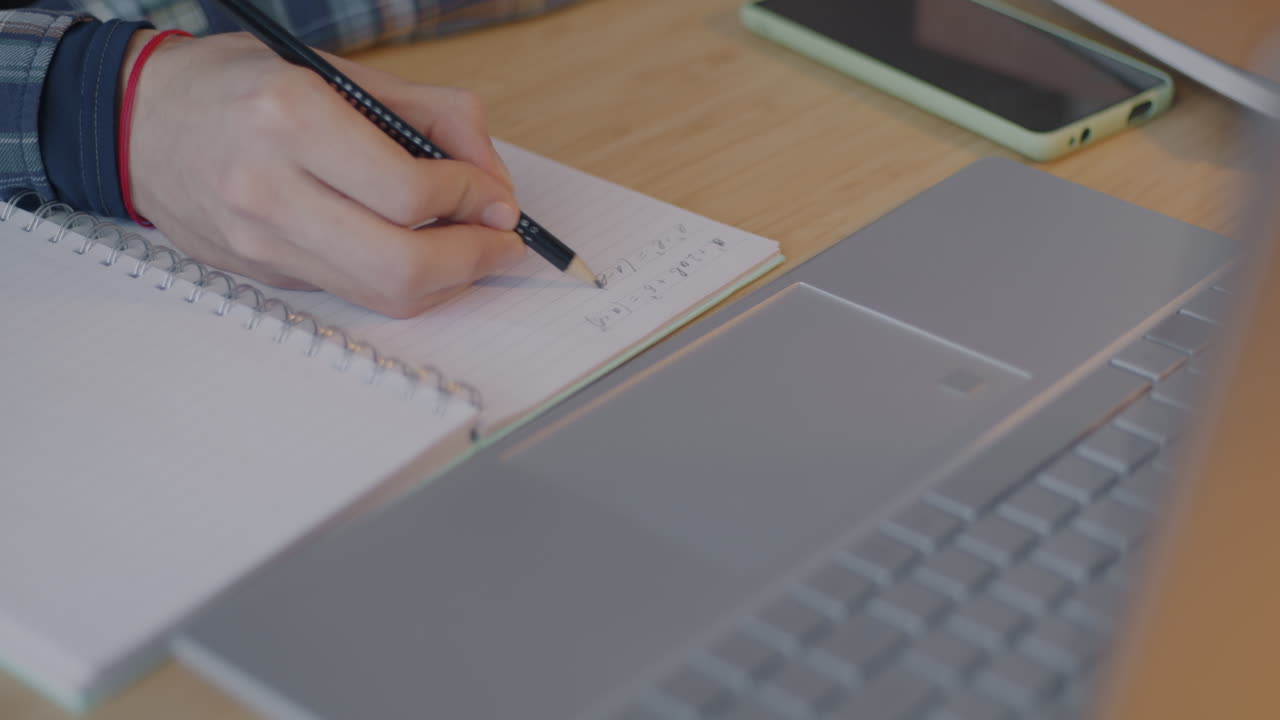 Student studying with a laptop and notebook