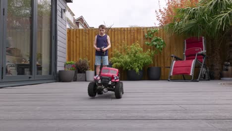 young boy at home outdoors in the garden playing with his rc car, truck, 4 x 4