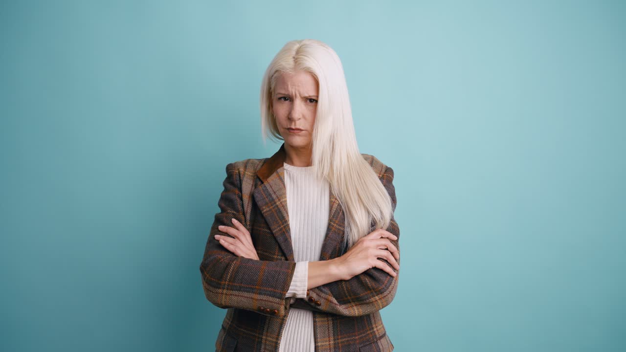 Annoyed Woman with Arms Crossed Frowning at Camera