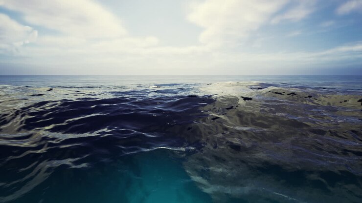L'acqua calma dell'oceano riflette la luce del sole sotto un cielo azzurro limpido a mezzogiorno