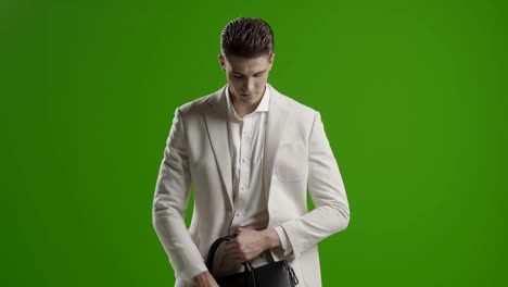 joven hombre de negocios guapo pantalla verde usando teléfono inteligente sonriendo tomando fotos selfie con el teléfono