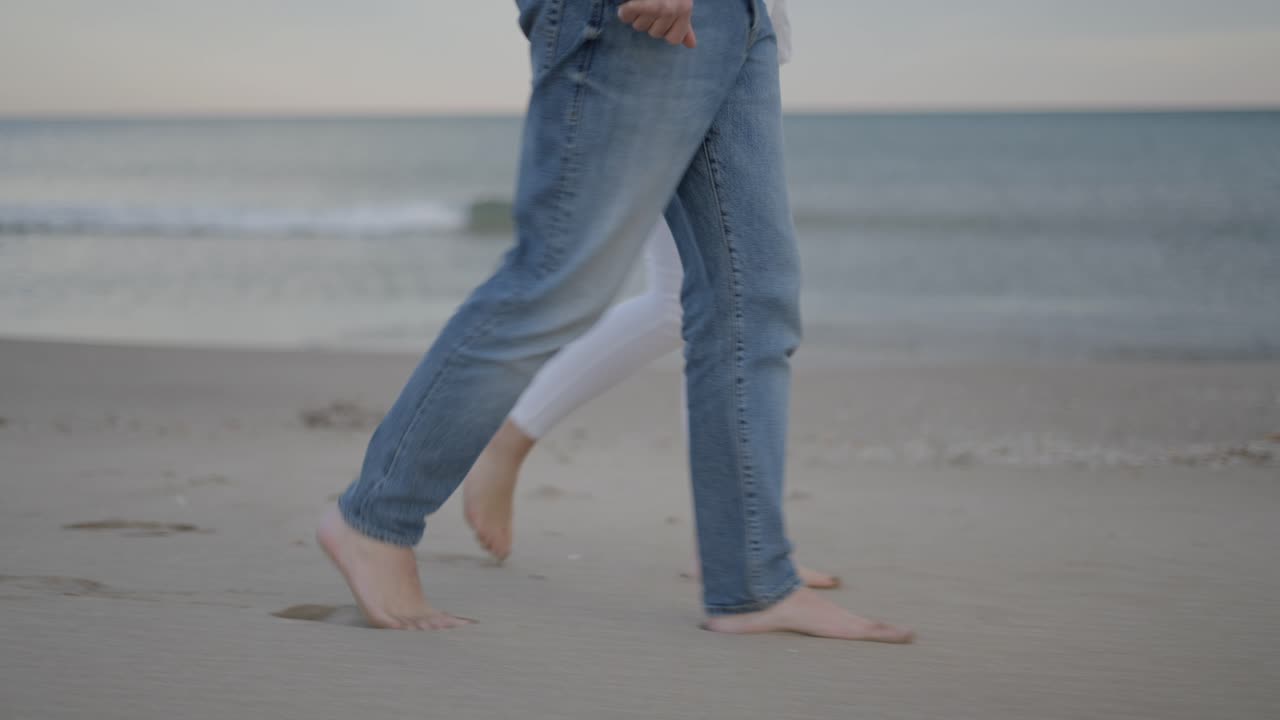 Couple walking barefoot on the beach