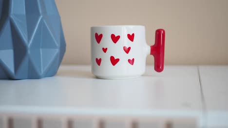 una taza elegante en forma de corazón en una mesa blanca