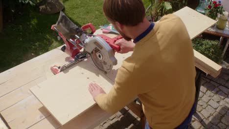 the craftsman saws a wooden panel with a circular saw