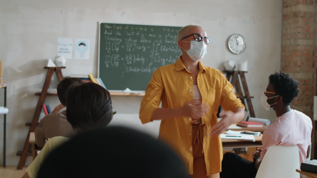 Insegnante donna con la mascherina che parla agli studenti a lezione