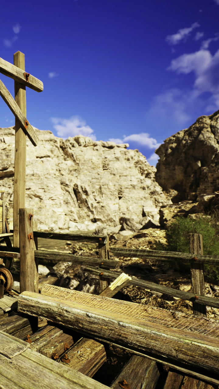 Old wooden structure overlooks a rugged canyon under a bright blue sky