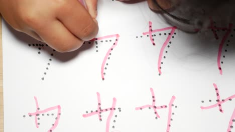 child practicing writing numbers