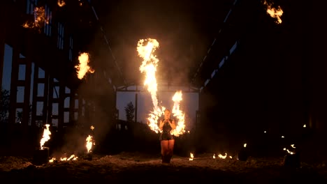 espectáculo de fuego profesional en el antiguo hangar de la aeronave muestran artistas de circo profesionales tres mujeres en trajes de cuero y un hombre con dos lanzallamas.