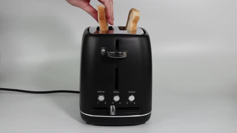 sequential demonstration of using a toaster to toast bread