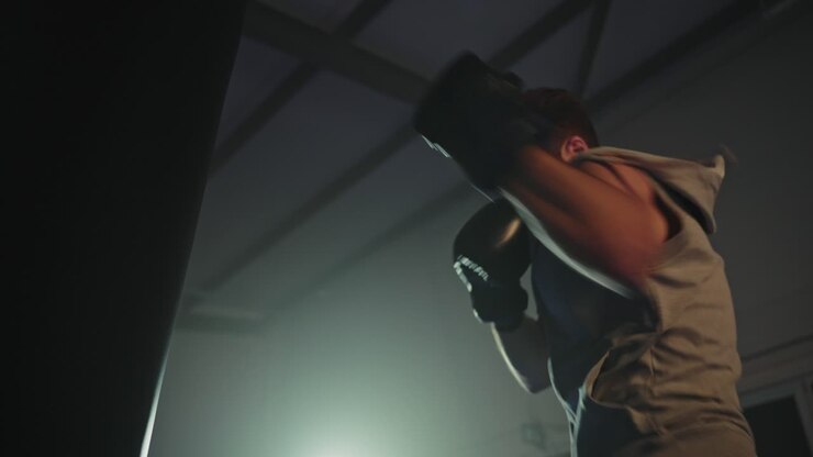 Uomo che si allena con un sacco da boxe