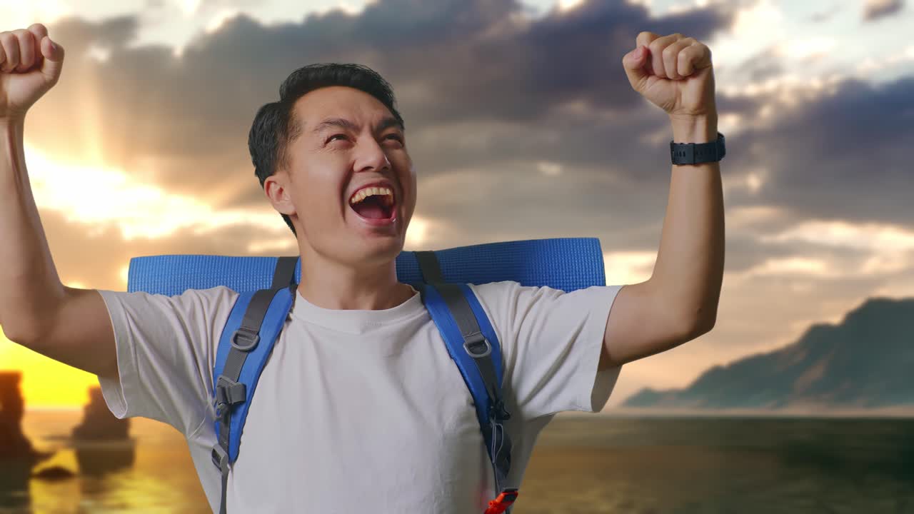 Close de um alpinista asiático com mochila de montanhismo gritando e comemorando o sucesso na praia