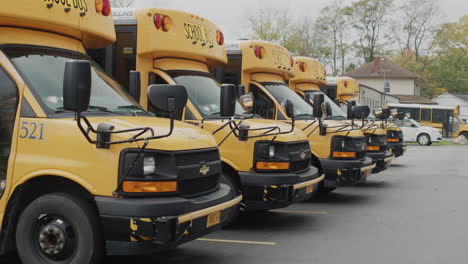 wilson, ny, usa, october 2021: several yellow school buses stand in a row in the parking lot near the school.