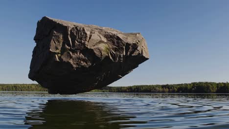 large rock floating on a lake