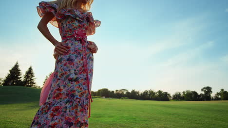 Cheerful-mother-with-daughter-dancing-on-green-grass.-Woman-and-girl-having-fun.