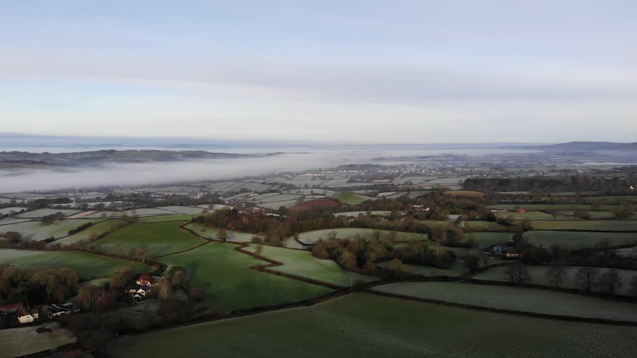 Aerial forward shot over the English Countryside on a frosty morning with river mist as a backdrop