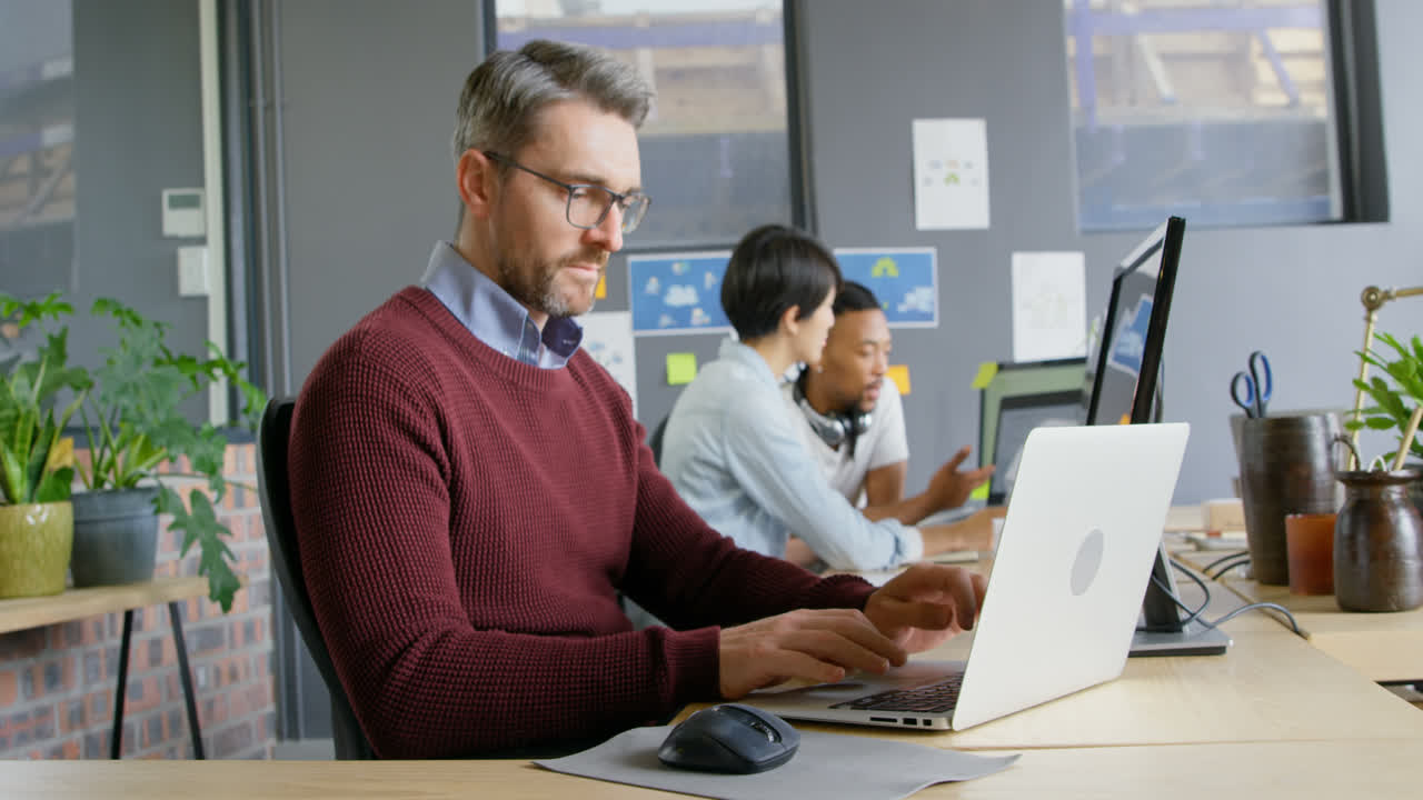ejecutivo masculino atento usando computadora portátil en la oficina 4k