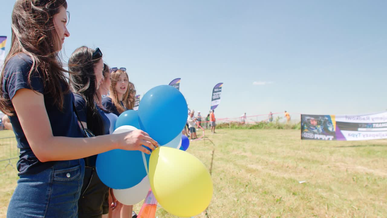 chica fanática de las carreras sosteniendo globos