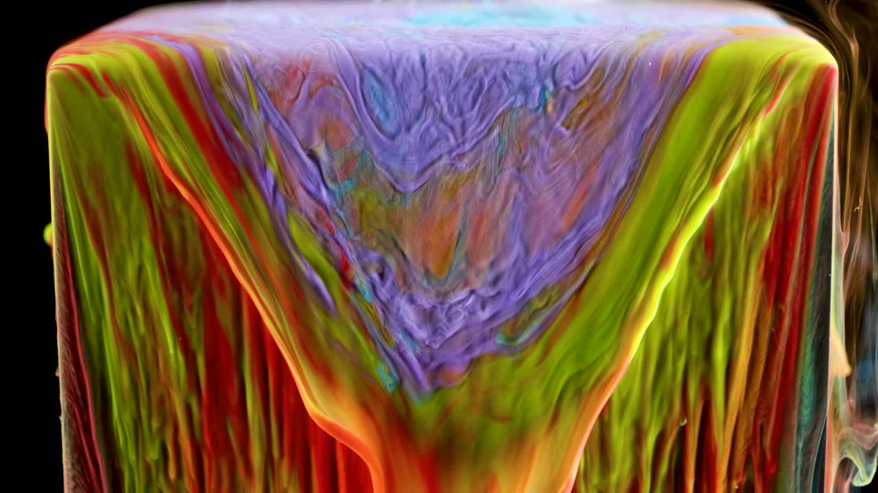 pintura de tinta multicolor fluye lentamente desde el cubo bajo el agua