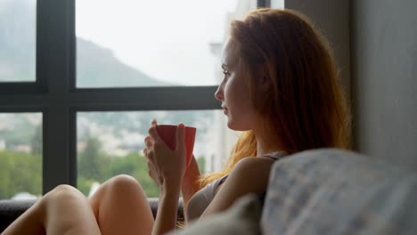 Woman-having-coffee-in-living-room-4k