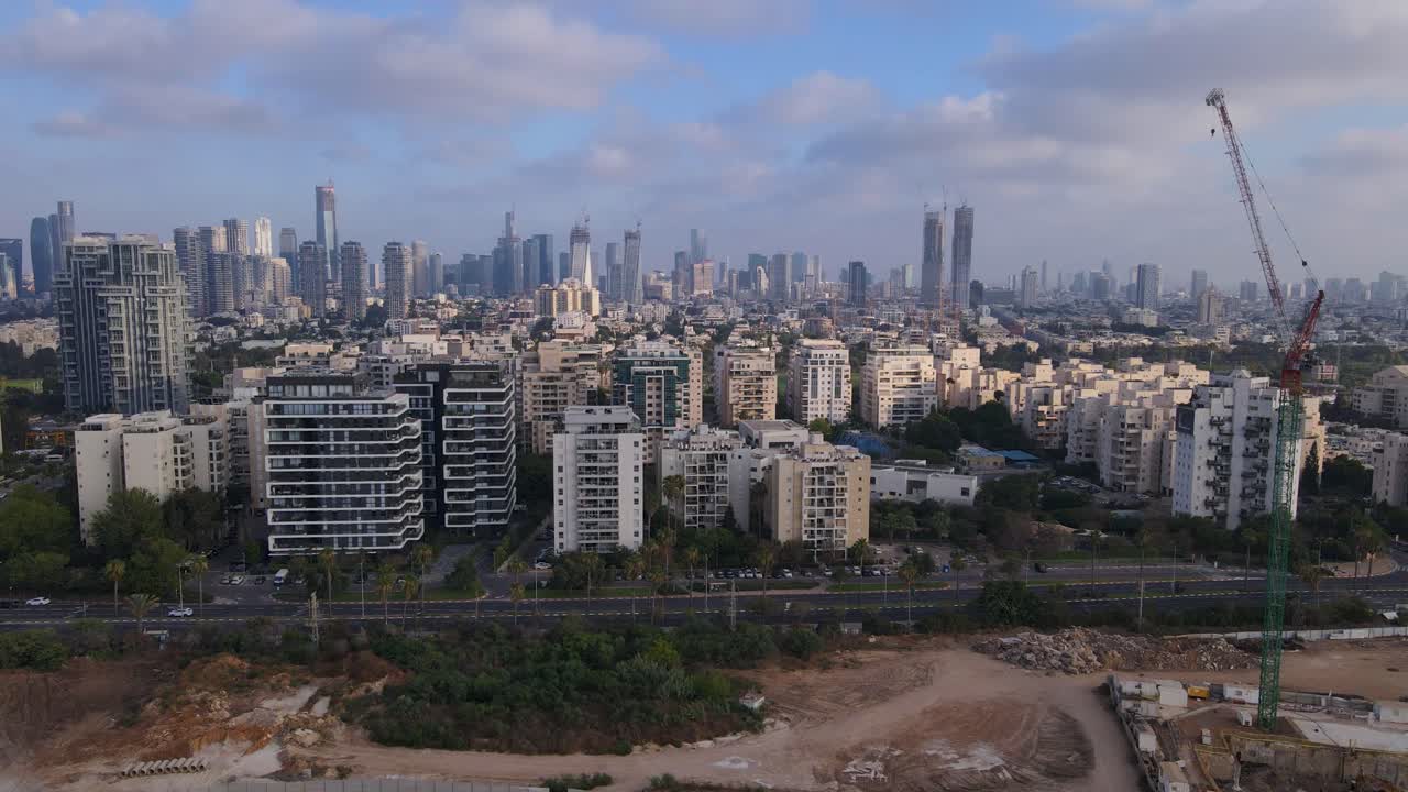Drone shows a construction site and skyline in Tel Aviv, with glass blown out on nearby buildings from a recent Iranian missile