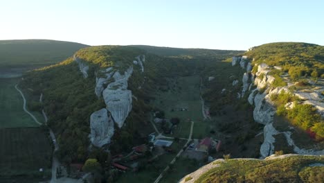 aerial view of a valley with rocky cliffs and forest