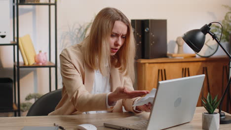 stressed businesswoman work at unpaid bank debt doing paperwork planning budget throws paper bills