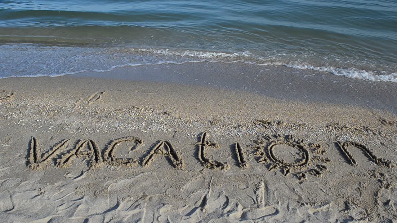 The inscription Vacation on sand. Inscription on sand
