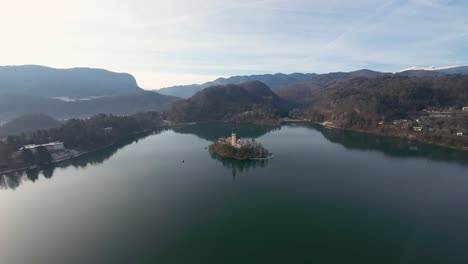 Wide-angle-shot-of-Bled-church-with-range-of-hills-at-background-in-Slovenia