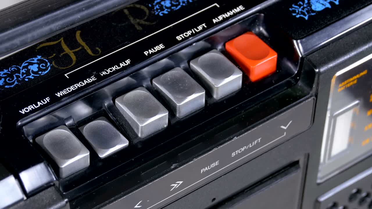 presionando el botón de un grabador de cinta, jugar, detener, grabar, ff, rew