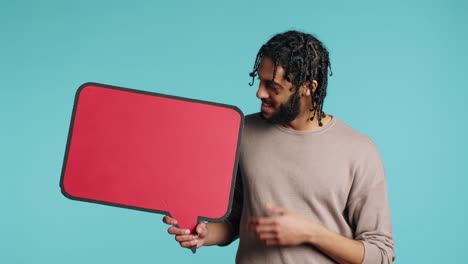 smiling man holding red speech bubble sign of empty copy space for message