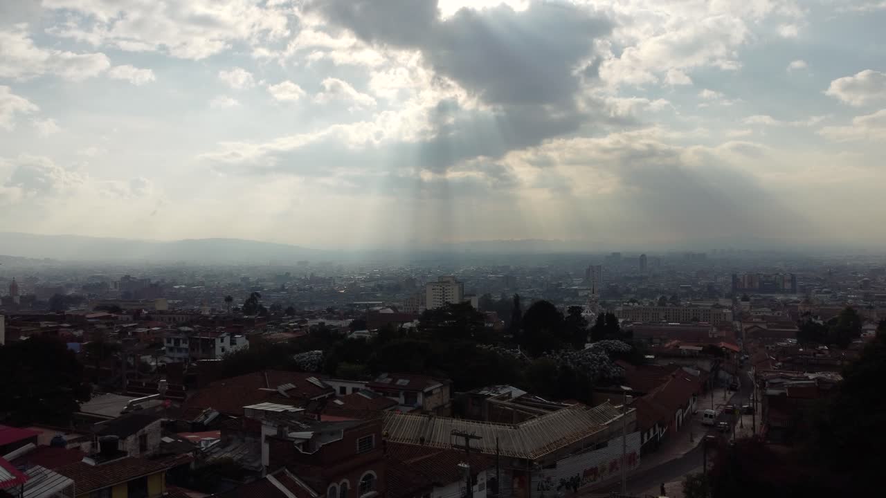 toma majestuosa del horizonte de bogotá con rayos de sol que atraviesan las nubes