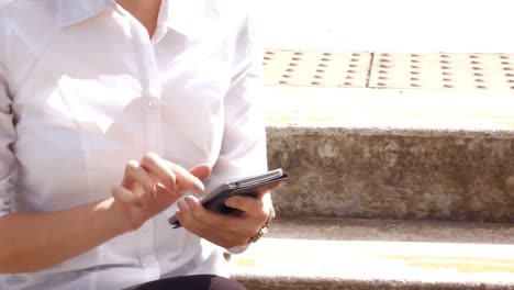Asian-businesswoman-using-her-phone-outside