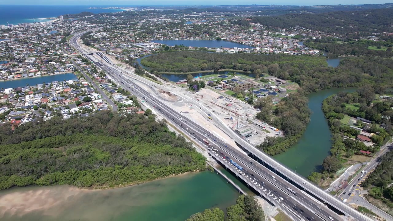 Luftfoto af køretøjer, der kører på Pacific Motorway, der strækker sig over Tallebudgera Creek i QLD, Australien. - Tilbagetrækningsoptagelse.
