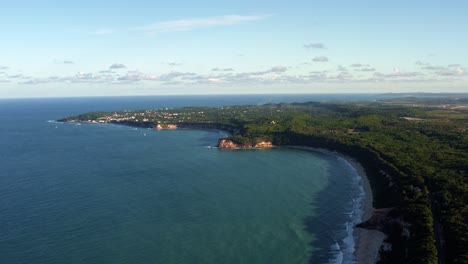 Extreme-wide-aerial-drone-shot-of-the-famous-tropical-Northeastern-Brazil-coastline-with-the-tourist-town-of-Pipa-in-the-background-and-beaches-surrounded-by-cliffs-in-Rio-Grande-do-Norte