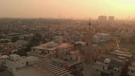 minarete aéreo pasado en la mezquita en karachi durante la puesta de sol naranja dorada