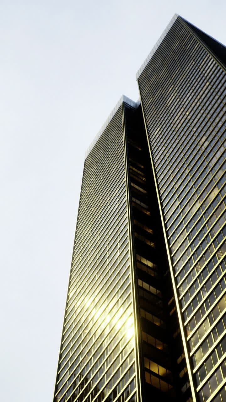 Altissimi grattacieli in vetro che riflettono la luce in uno skyline urbano al crepuscolo