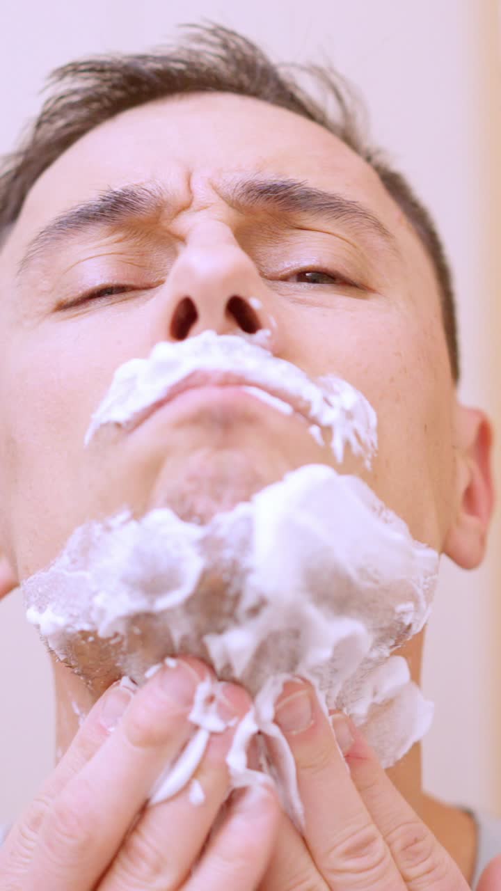 Man applying shaving foam on his face in bathroom