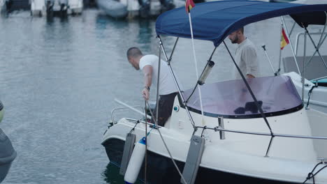 men preparing a boat in a marina