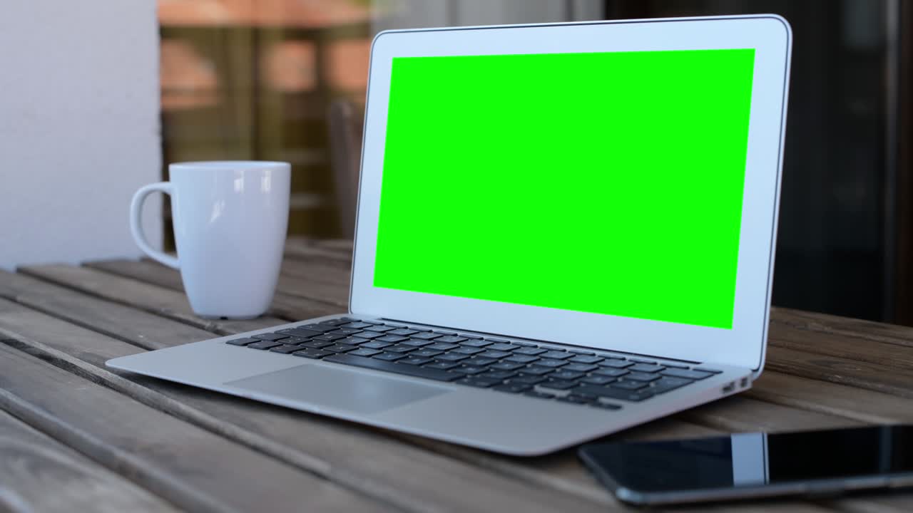 Laptop computer blank empty mock up green screen on hotel balcony, working on vacation concept
