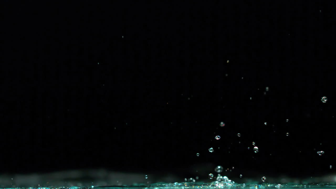 Green toy car rolling over puddle and splashing on black background