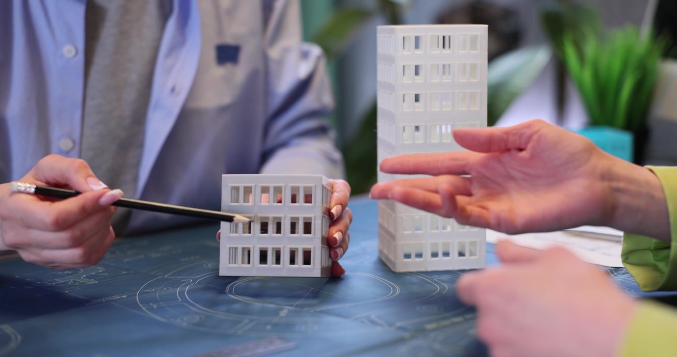 Architetti progettisti discutono di edilizia usando modelli in plastica.