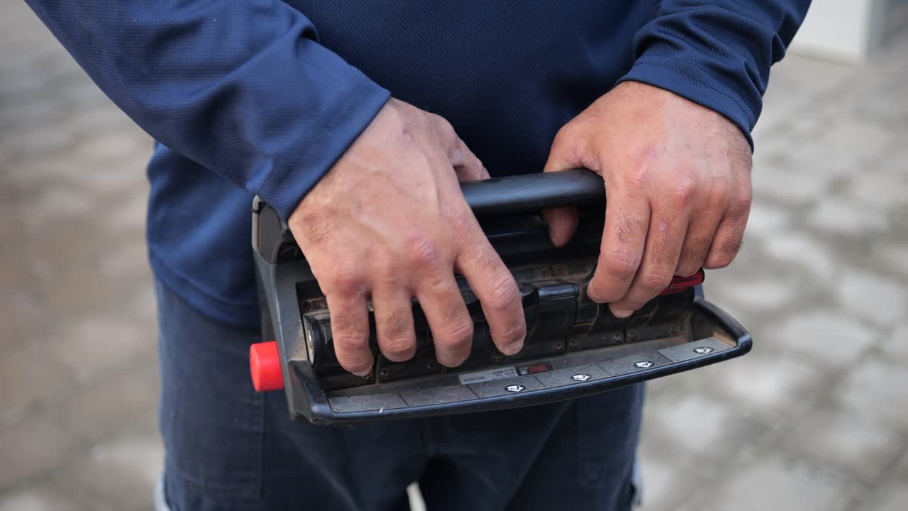 manos de un operador que utiliza el controlador de un brazo mecánico para la recogida de residuos